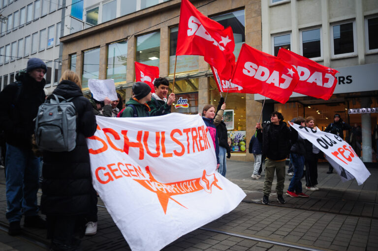 Schüler stehen in Kassel auf den Gleisen der Tram mit einem Transparent "Schulstreik gegen Wehrpflicht".